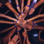 Overview shot of several people putting hands into the center