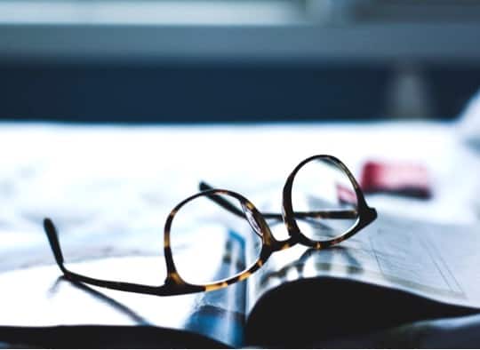 Pair of glasses on an open book