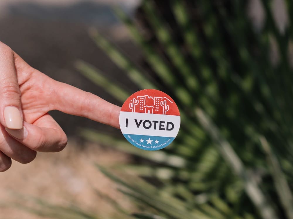 Woman holding an I Voted sticker