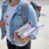 Student walking to school with books and a backpack