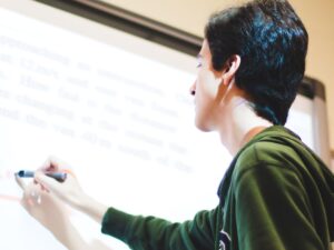 High school student writing on a whiteboard