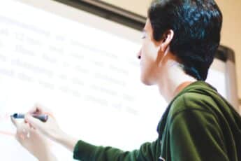 High school student writing on a whiteboard