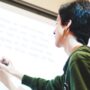 High school student writing on a whiteboard