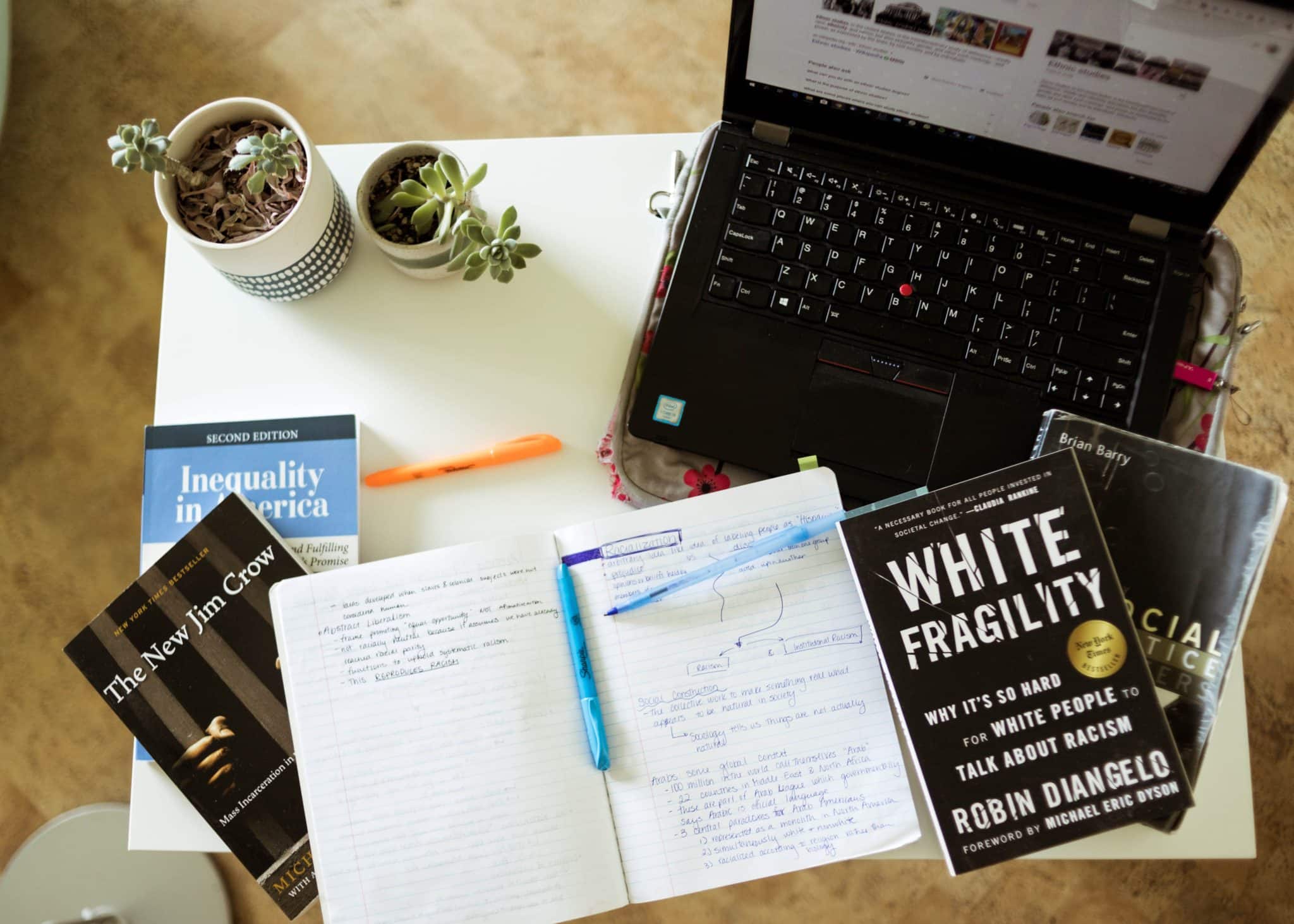 Antiracist books, notebook, laptop