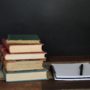 Stack of books and a notebook and pen