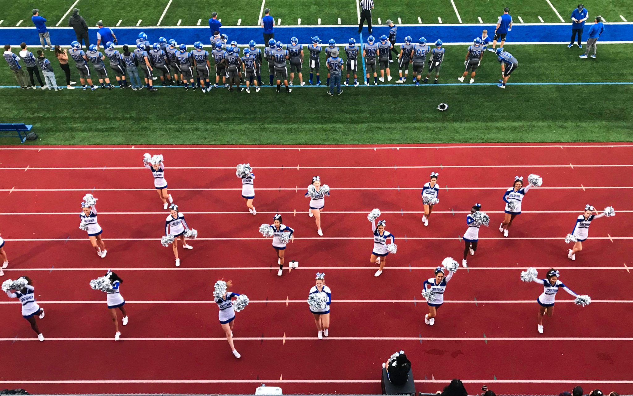Aerial shot of cheerleaders on the track at a football game