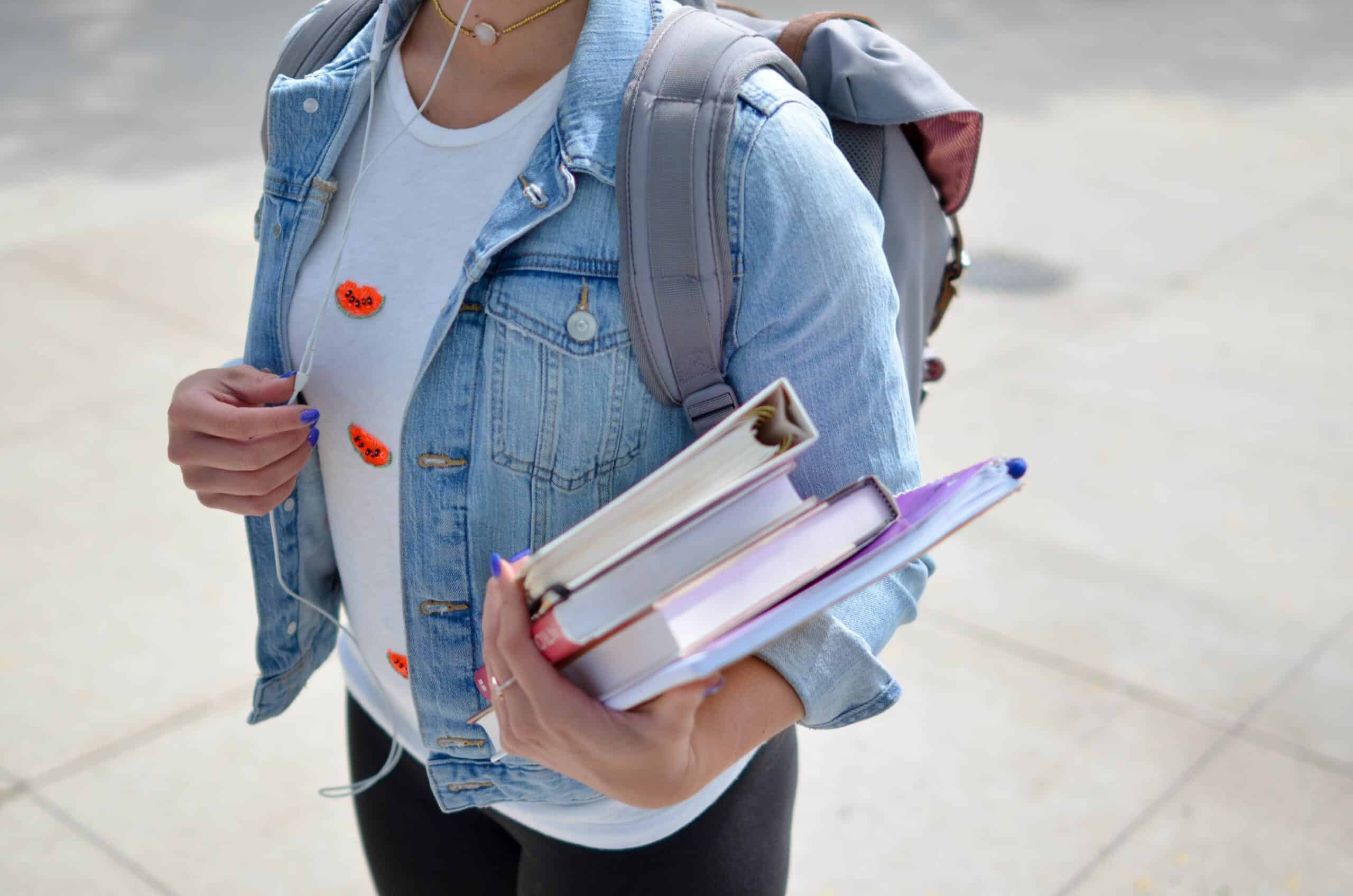 Student walking to school with books and a backpack